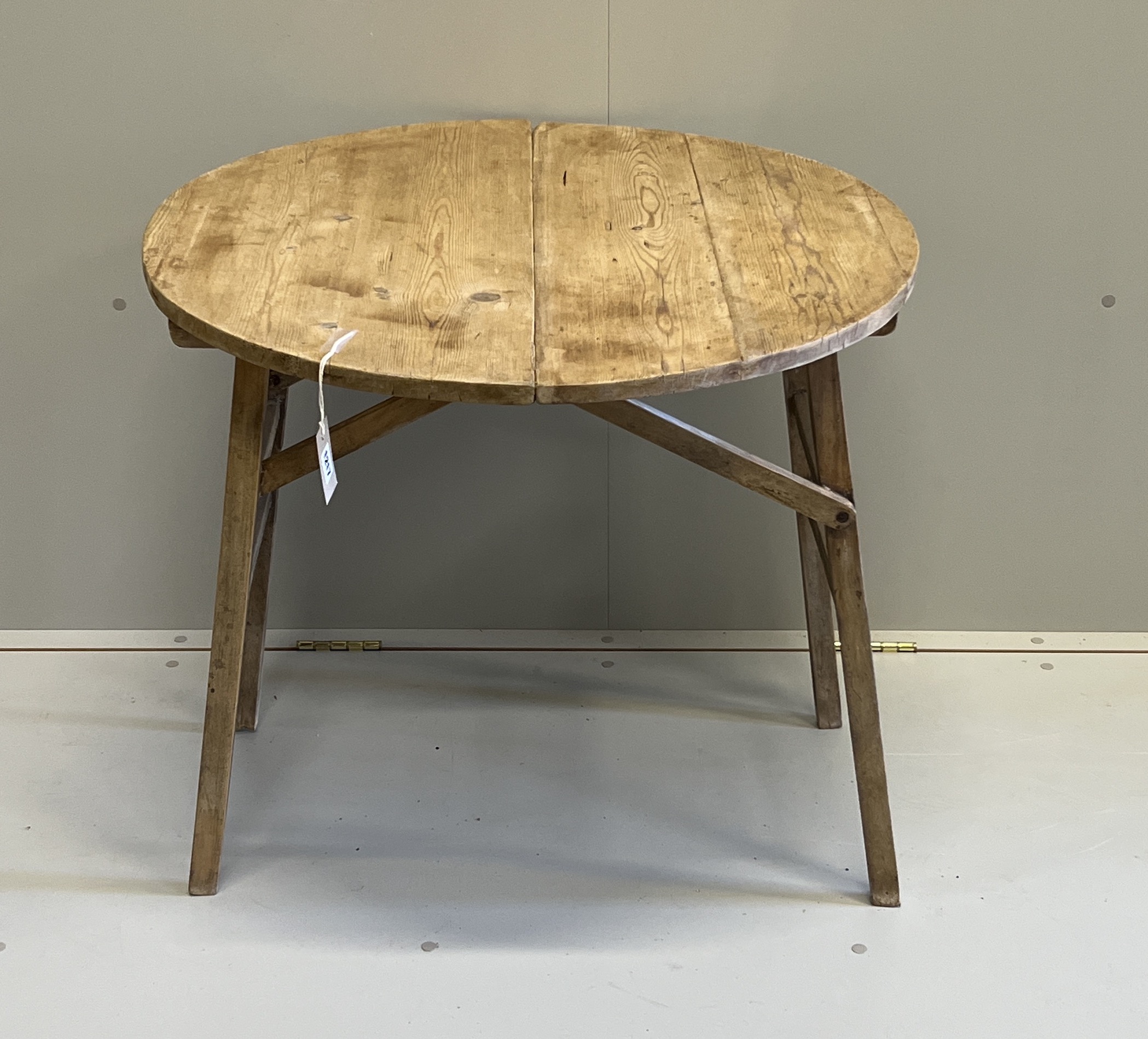 A 19th century French circular pine folding occasional table, diameter 75cm, height 68cm